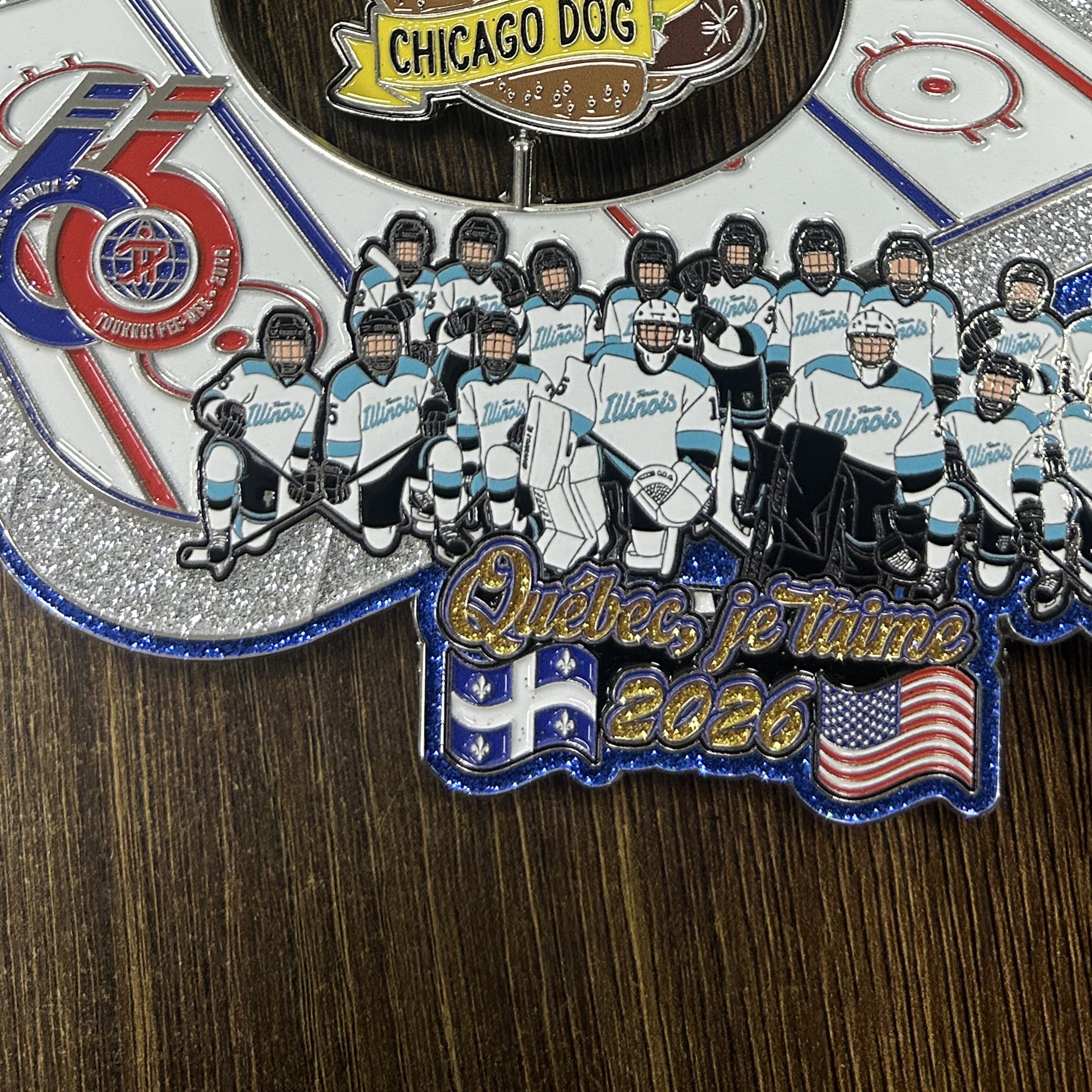 Privacy-safe documentary close-up of a manufactured hockey trading pin showing glitter enamel, metal edges and a moving center spinner.